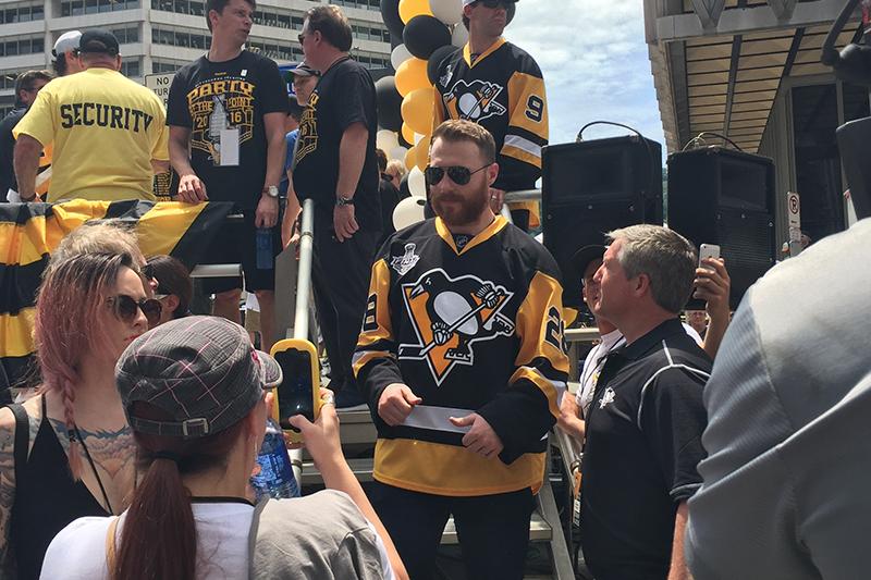 Defenseman Ian Cole talks to the media as he exits the stage.