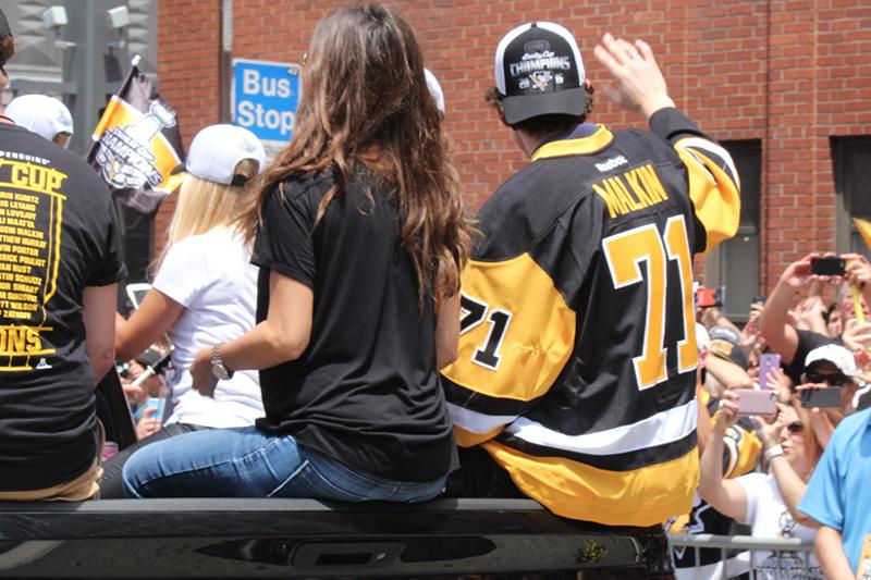 Evgeni Malkin (71) waves to fans as he rides  through streets of the parade.