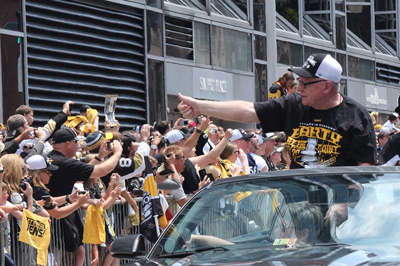 Penguins General Manager Jim Rutherford gives a thumbs up to the parade crowd.