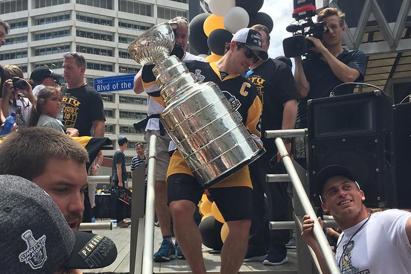 Sidney Crosby carries the Stanley Cup from the stage to finalize the celebration.