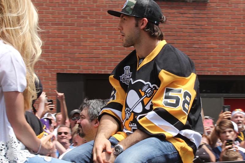 Defenseman Kris Letang looks into the crowd as he rides down the street.