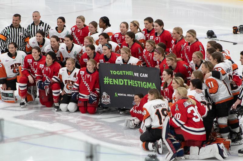 Both teams gather around the #EndtheStigma banner before the start of the Mental Health Awareness game. Neville Island, PA Friday Jan. 25, 2019. (RMU Sentry Media/Samuel Anthony)