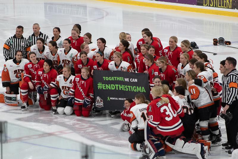 Both teams gather around the #EndtheStigma banner before the start of the Mental Health Awareness game. Neville Island, PA Friday Jan. 25, 2019. (RMU Sentry Media/Samuel Anthony)