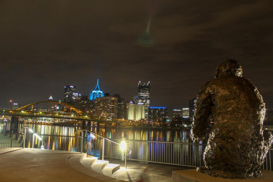 A statue of Mister Rogers looks over the Downtown Pittsburgh skyline from the Fred Rogers Memorial Statue on the North Shore. Photo Date: March 29, 2019 Photo Credit: (RMU Sentry Media/Gage Goulding)