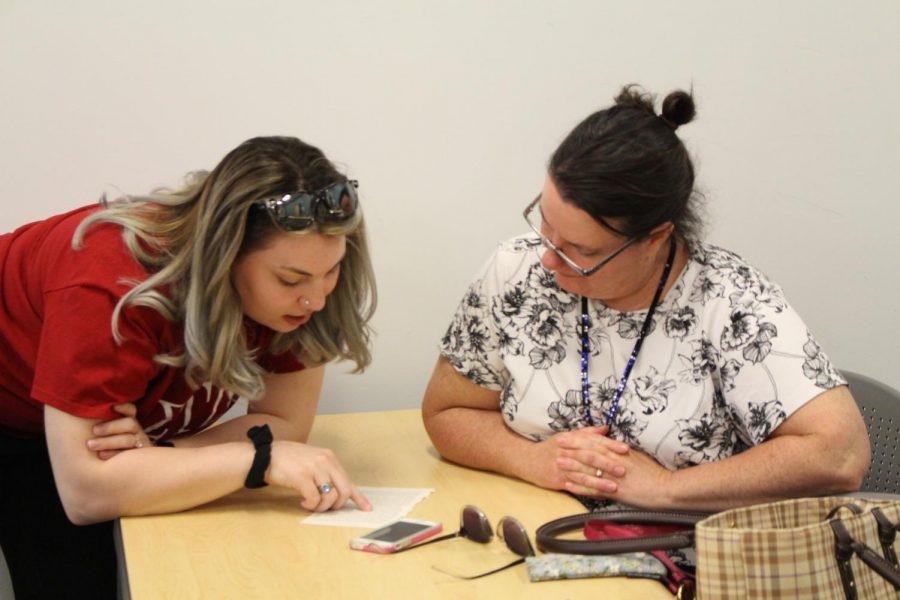 Sigma Tau Deltas Celia Smith shows an attendee how to do blackout poetry. Moon, PA. April 18, 2019. RMU Sentry Media/Garret Roberts. Photo credit: Garret Roberts Photo credit: Garret Roberts