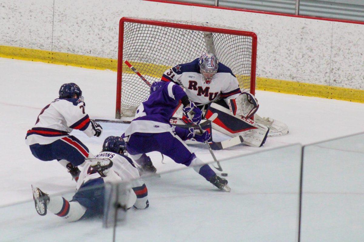 Walker+Sommer+attempts+a+shot+against+Noah+West+in+the+Purple+Eagles+3-2+double-overtime+win+against+RMU.+Photo+Credit%3A+Nathan+Breisinger