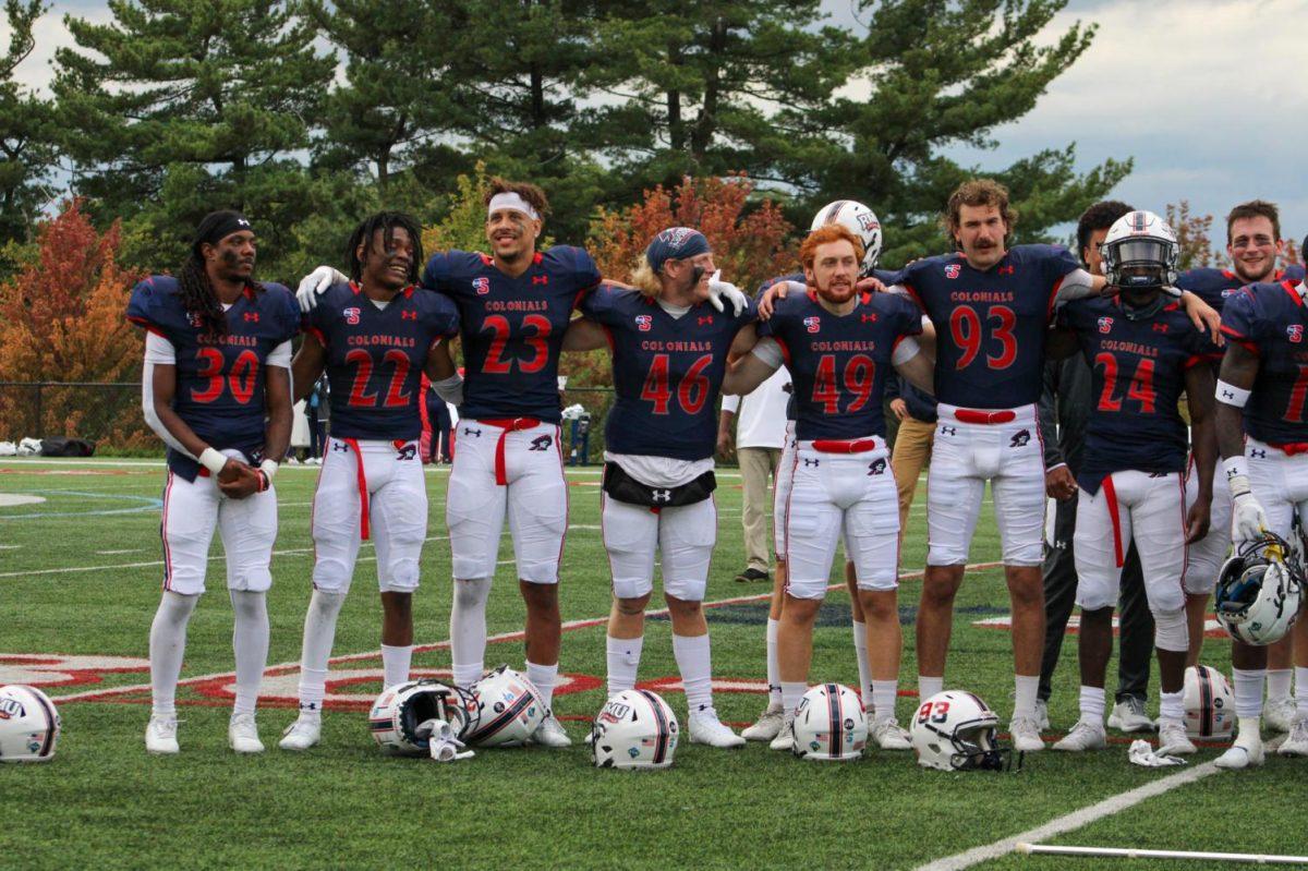 The football team locks arms after a win at home against Howard. Photo credit: Tyler Gallo