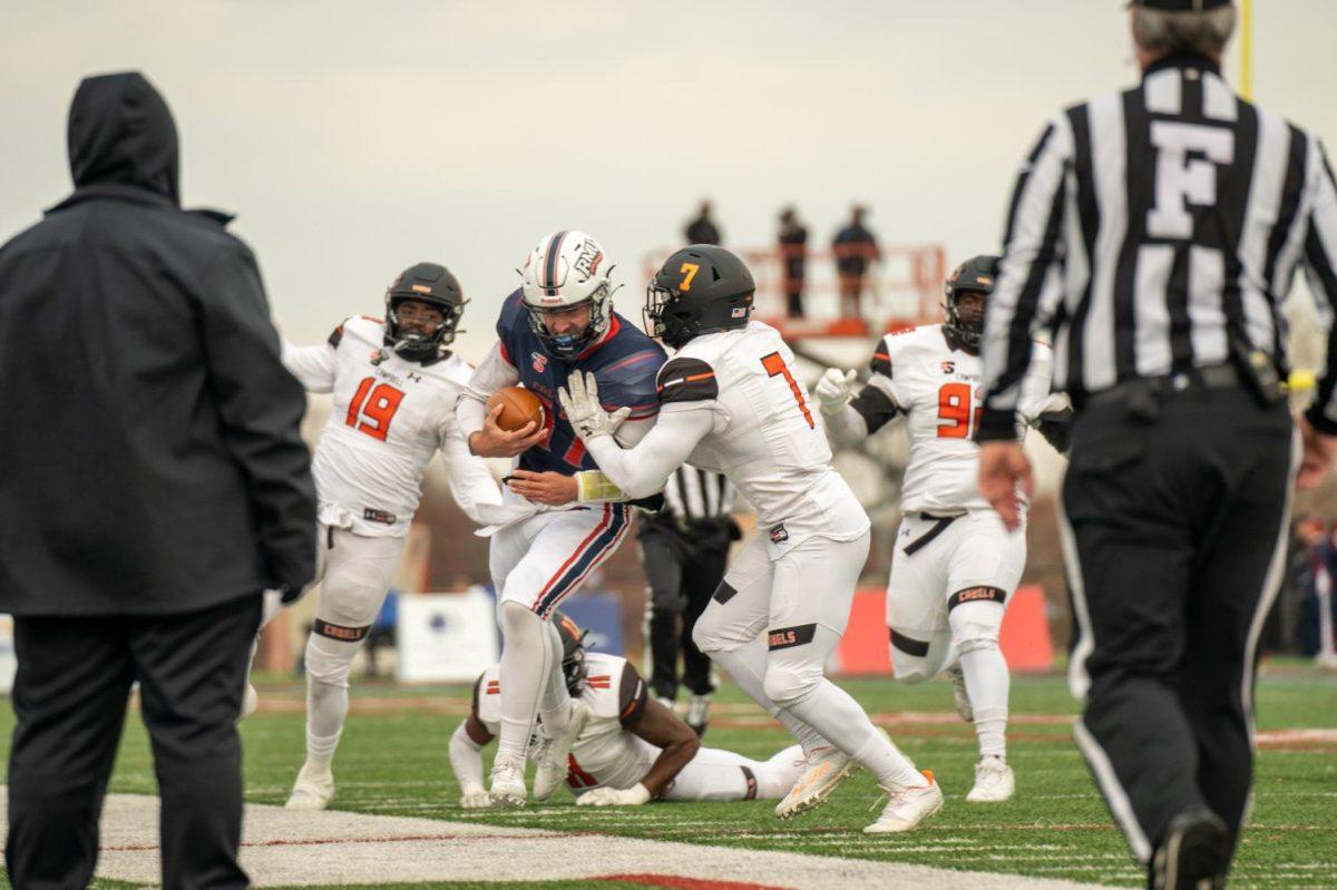 George Martin is converged on by two Campbell players during a rush. Photo credit: Justin Newton