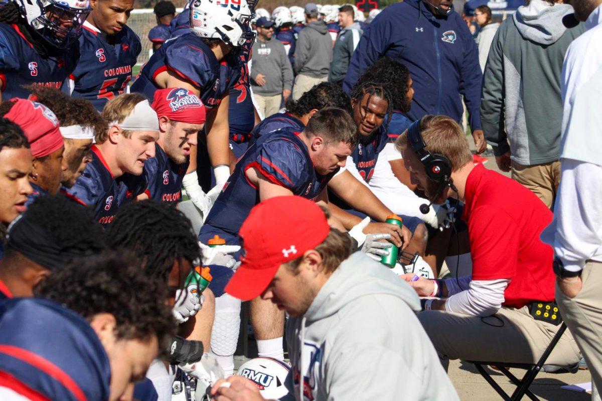 Assistant coach/Defensive coordinator Dave Plungas meets with the defense against Kennesaw State. Photo credit: Tyler Gallo