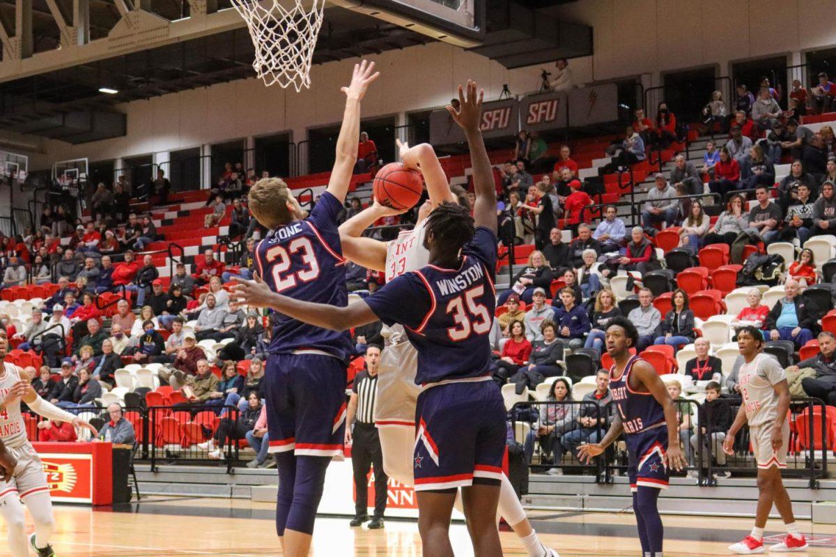 Robert Morris center Brandon Stone and forward Justin Winston contest Saint Francis forward Josh Cohens shot Wednesday night. Photo credit: Nathan Breisinger