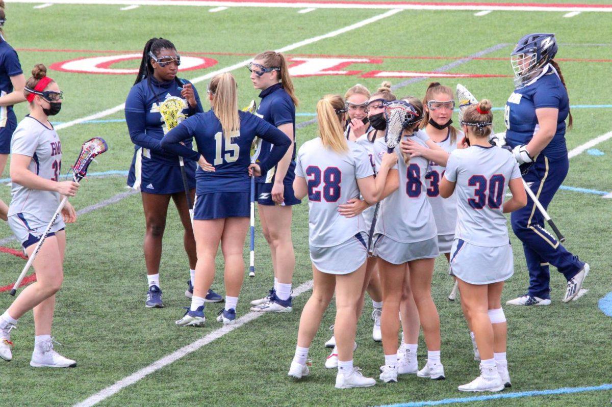 Womens lacrosse celebrates a goal against Akron. Photo credit: Nathan Breisinger