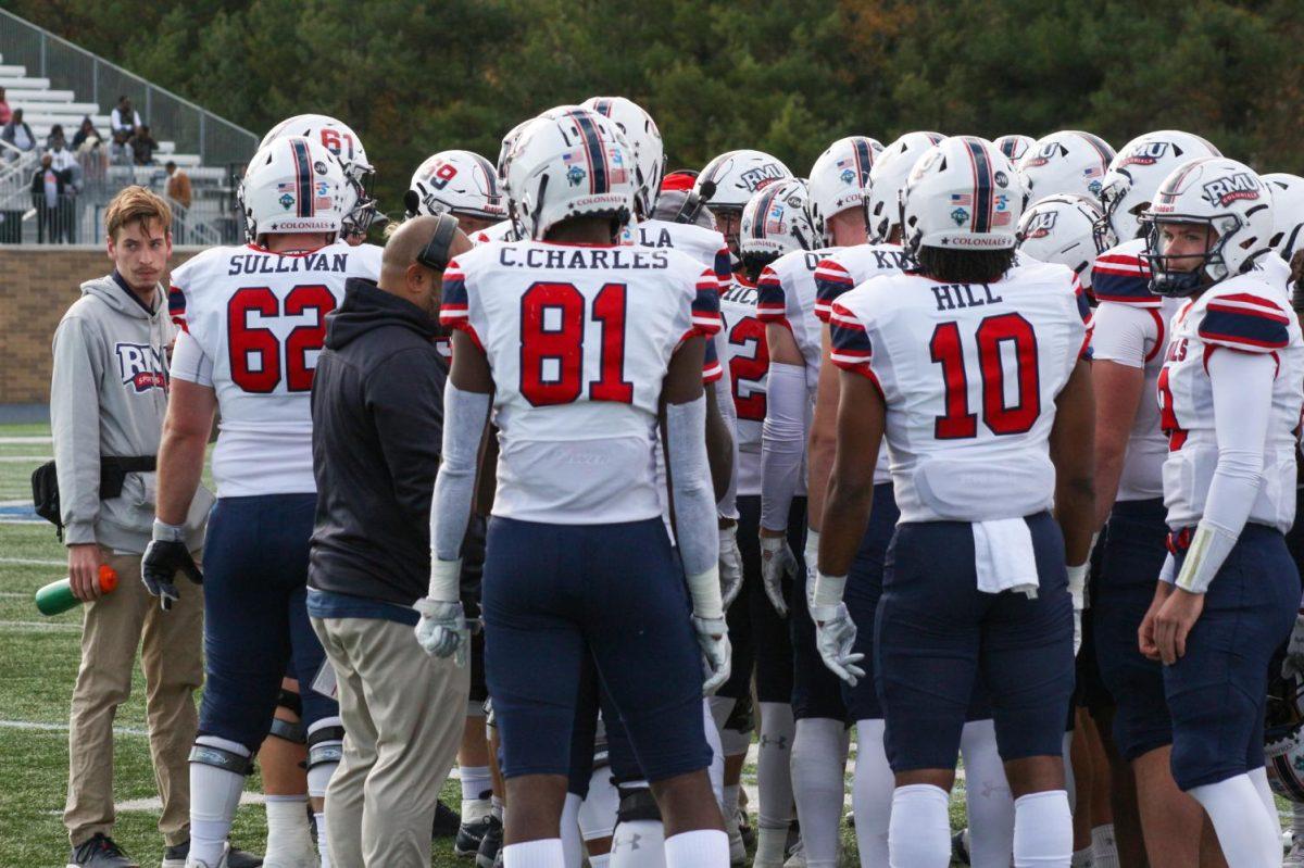 RMU+football+meets+before+a+snap+against+Monmouth.+Photo+credit%3A+Jonathan+Hanna