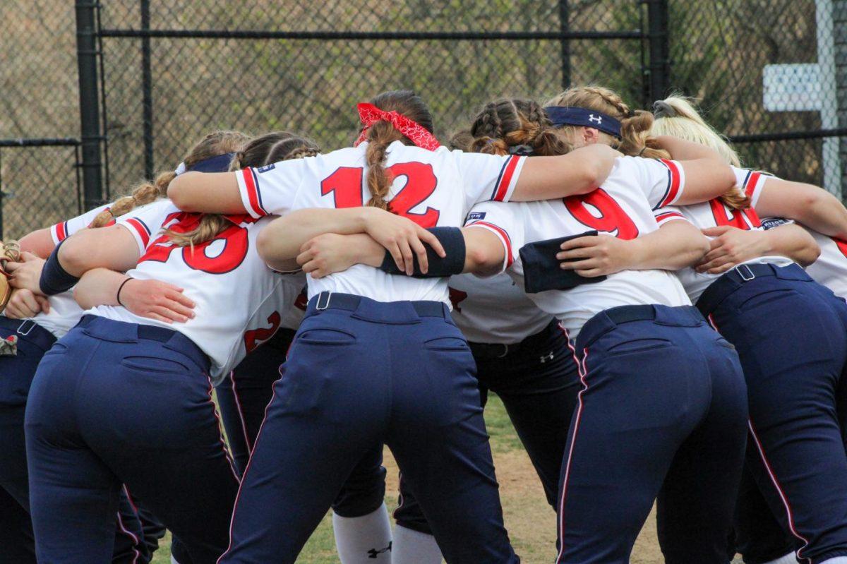 RMU Softball huddles before their game against UIC. Photo credit: Tyler Gallo