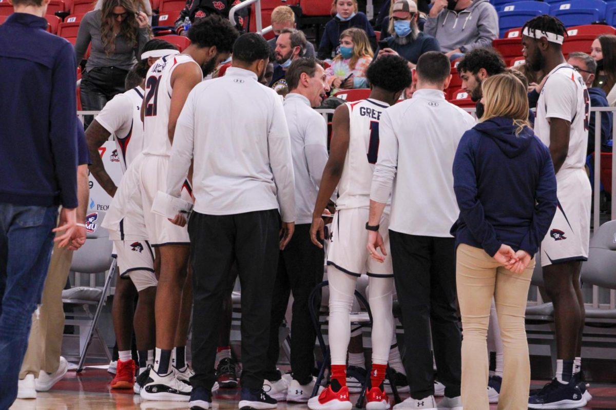 The team huddles up during a timeout during a game against Lancaster Bible College on December 8, 2021