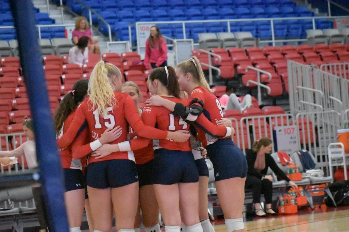 The team celebrates a point in the three-set loss to Green Bay