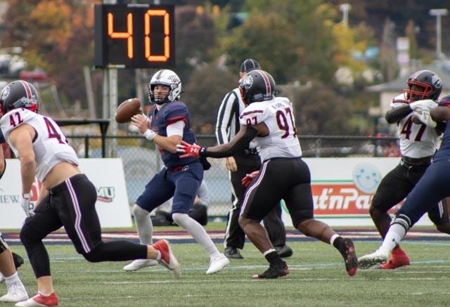 Zach Tanner takes the snap and scrambles away from the defender Photo credit: Bailey Noel